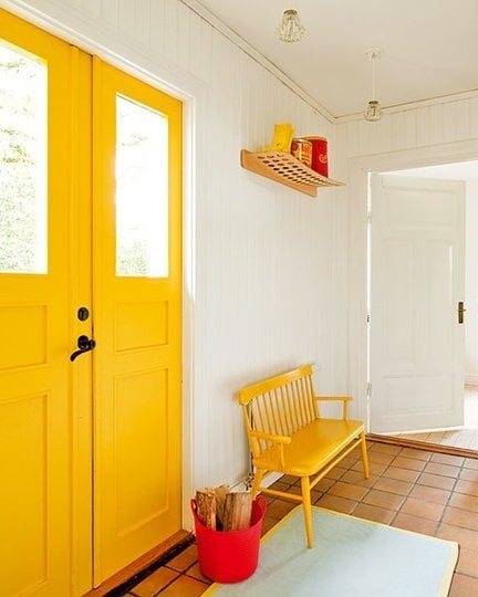 Brigth Yellow Door and bench in white entry room