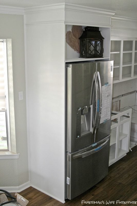 built-in fridge enclosure in a small white kitchen, Fisherman's Wife Furniture featured on Remodelaholic.com