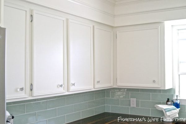 glass knobs and molding on white kitchen cabinets with glass subway tile backsplash, Fisherman's Wife Furniture featured on Remodelaholic.com