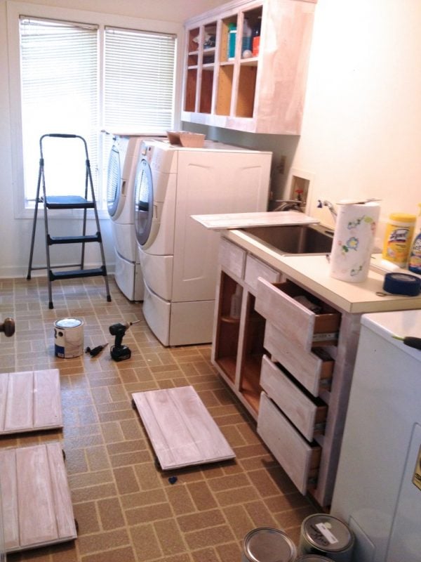 low cost laundry room makeover with painted cabinets, featured on Remodelaholic