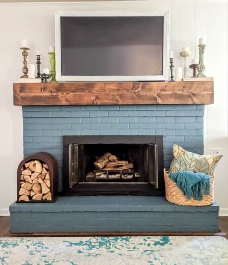 Blue Painted Brick Fireplace With Rustic DIY Mantel, Lovely Etc Featured On Remodelaholic
